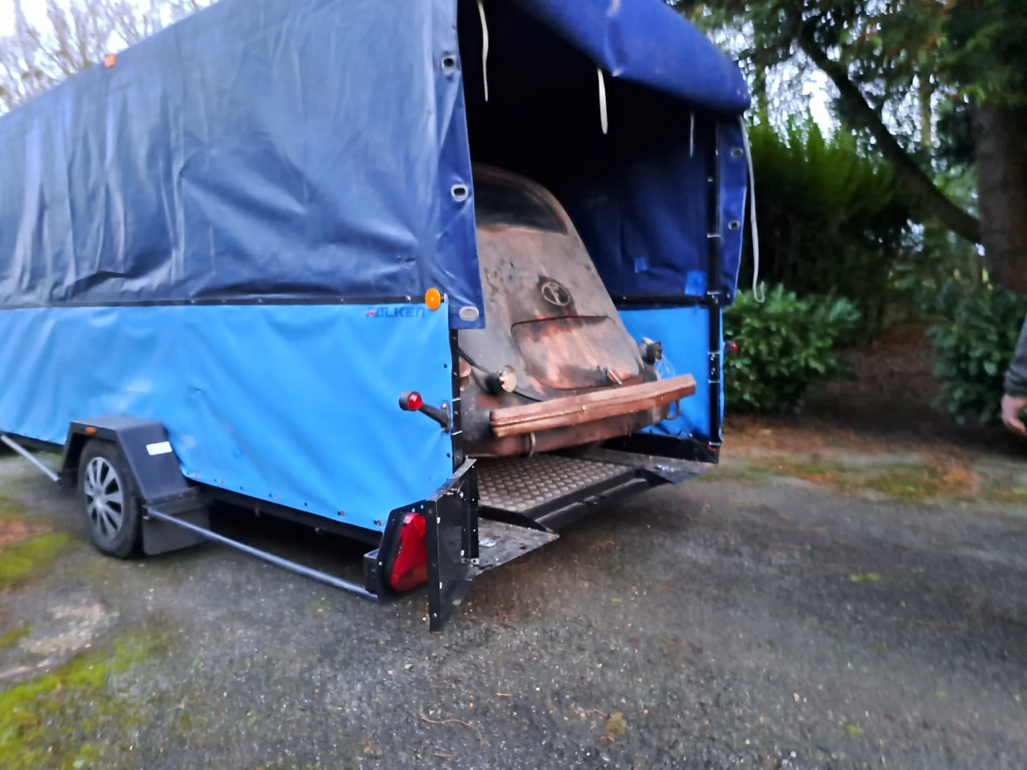 Véhicule ancien sur le plateau de dépannage qui est baché